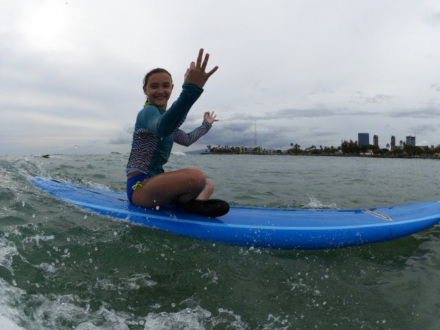 A girl sitting on her board riding a wave. Provided by Polu Lani Surf.